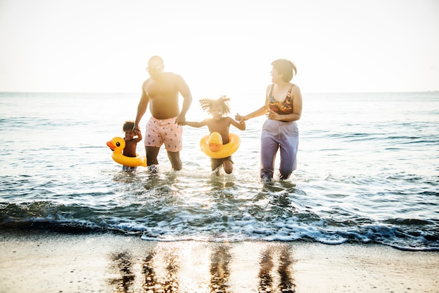 Familie, die zusammen am Strand spielt