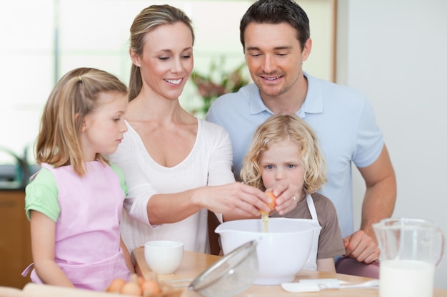 Familie, die zusammen Teig zubereitet