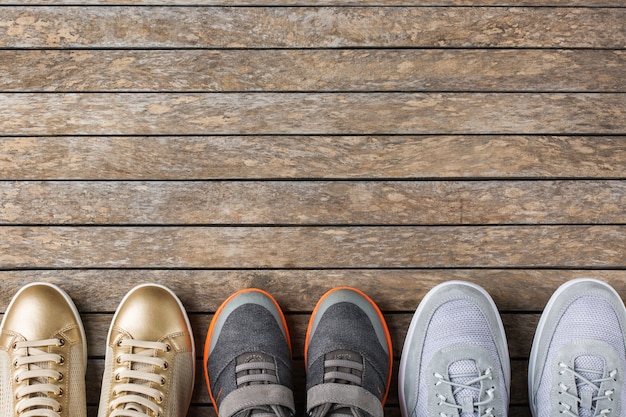 Foto familie, eltern und kinderkonzept. schuhe für mutter, vater und kind, kind. kopieren sie platz, ansicht von oben, flach