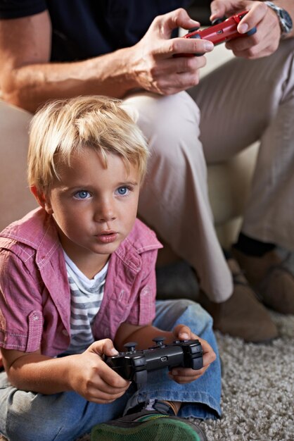 Foto familie ernsthaft und junge kind spielen auf dem boden im wohnzimmer des hauses mit dem vater für liebe wettbewerb oder kindentwicklung videospiel-controller für die nächste ebene und sohn gamer spielen mit dem vater