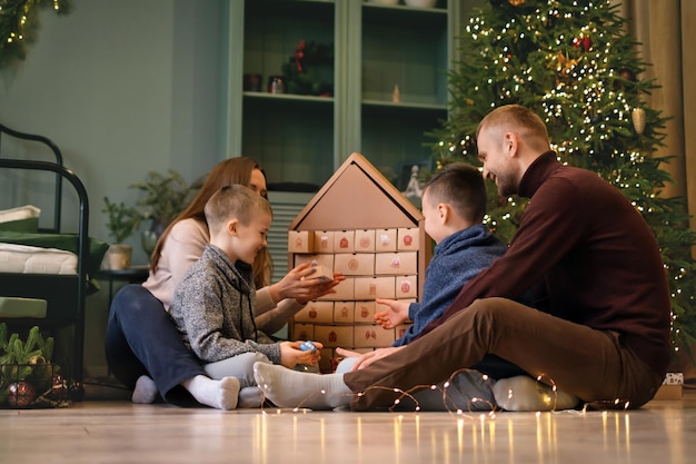 Familie eröffnet Zweige im Adventskalender mit der Nummer 30