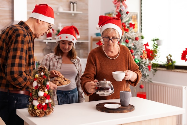 Familie feiert zusammen Weihnachtszeit in weihnachtlich dekorierter kulinarischer Küche