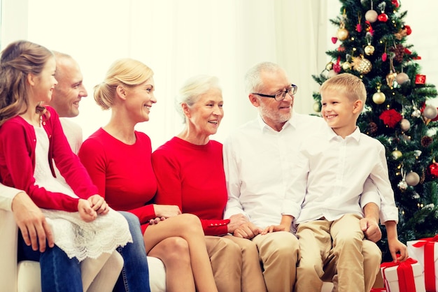 familie, feiertage, generation, weihnachten und personenkonzept - lächelnde familie, die zu hause auf couch sitzt