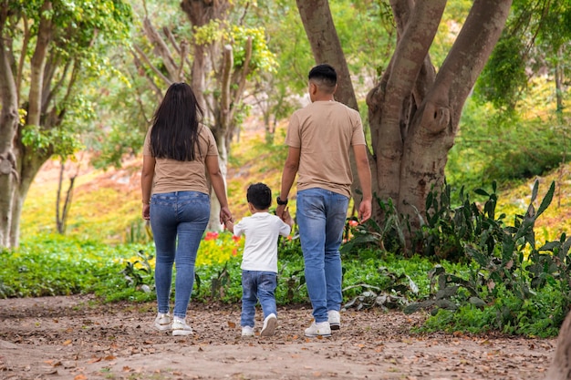 Familie geht Händchen haltend durch einen Park in Peru