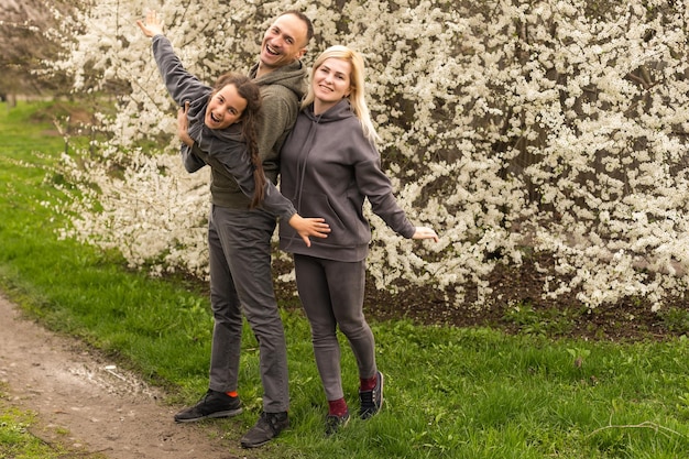 Familie im blühenden Garten mit Bäumen.