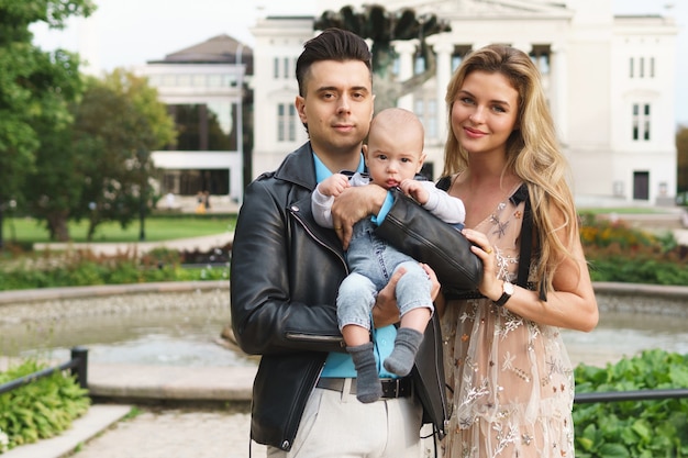 Familie im Stadtpark. Junges glückliches Paar mit dem kleinen Jungen