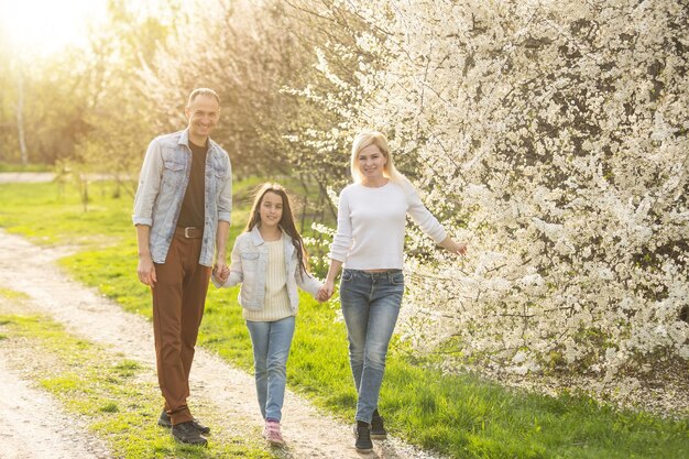 Familie in einem blühenden Frühlingsgarten. Konzept der glücklichen Familie