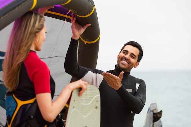 Familie in Neoprenanzügen mit Surfbrettern