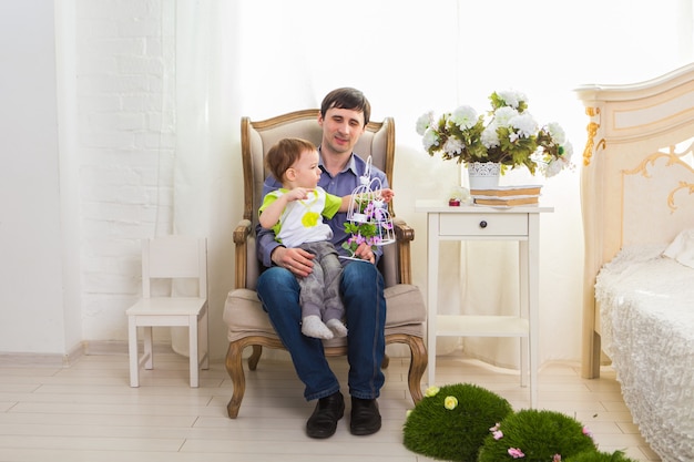 Familie, Kindheit, Vaterschaft, Aktivität und Menschenkonzept - glücklicher Vater und kleiner Sohn, die zu Hause spielen.