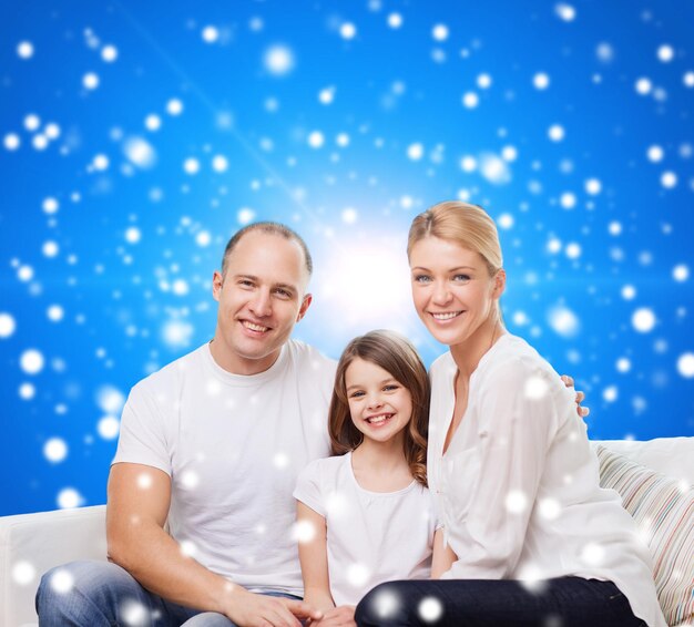Familie, Kindheit, Weihnachtsferien und Menschen - lächelnde Mutter, Vater und kleines Mädchen auf blauem, schneebedecktem Hintergrund