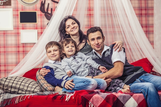 Familie Mama Papa und Kinder zusammen zu Hause in der gemütlichen Atmosphäre der Schlafzimmer im Winter Interieur