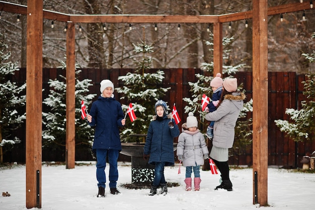 Familie mit dänischen Flaggen im Winter im Freien Reisen Sie in die skandinavischen Länder Glücklichste dänische Völker