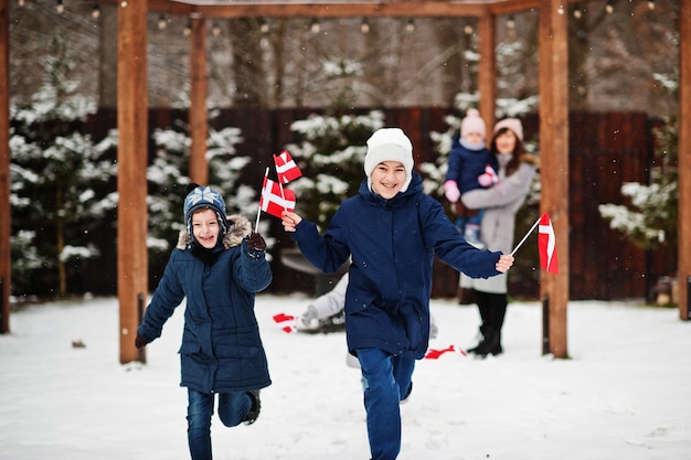Familie mit dänischen Flaggen im Winter im Freien Reisen Sie in die skandinavischen Länder Glücklichste dänische Völker