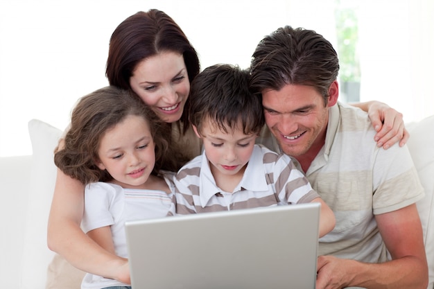 Familie mit einem Laptop auf dem Sofa