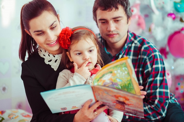 Familie mit einer kleinen Tochter ein Buch zu lesen