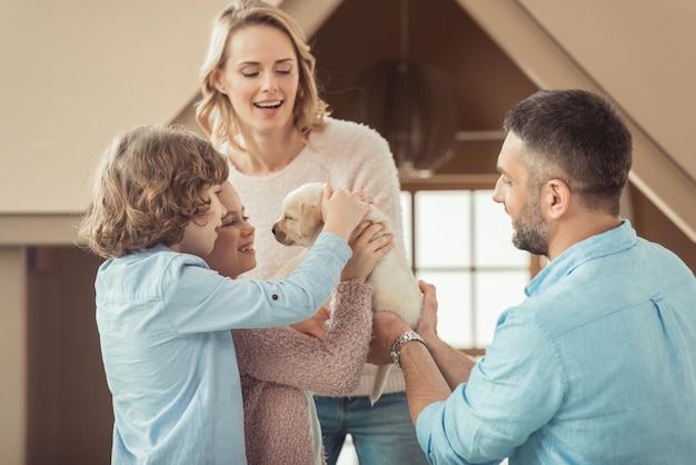 Familie mit entzückendem Labrador-Welpen vor Papphaus