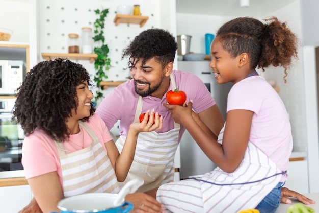 Familie mit entzückenden Töchtern, die sich in einer modernen Küche versammelt haben, um gemeinsam zu kochen. Genießen Sie Kommunikation und Kochhobby-Konzept