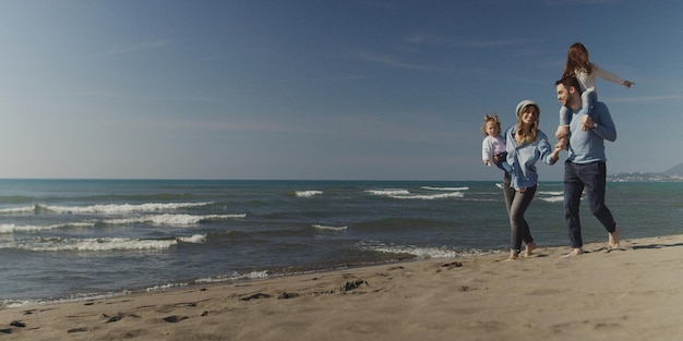 Familie mit Kindern, die sich während des Herbsttages am Strand ausruhen und Spaß haben