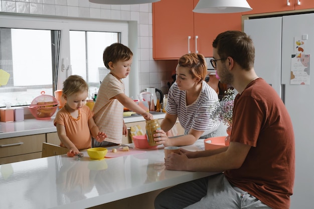 Familie mit Kindern, die zu Hause in der modernen Küche kochen