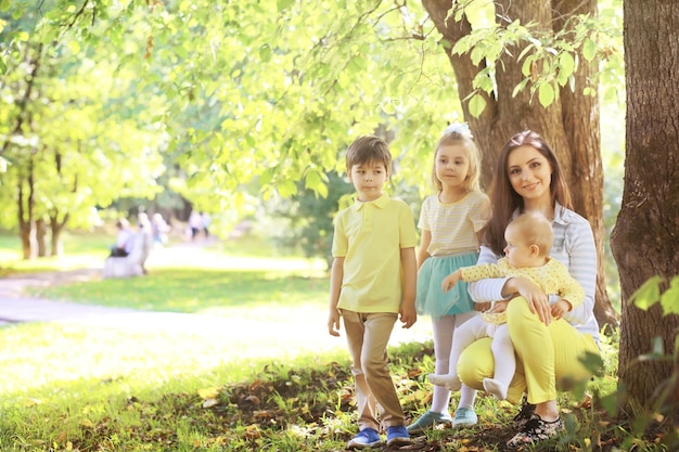 Familie mit Kindern für einen Spaziergang im Sommerpark. oming Herbst im Park. Familie. Herbst. Glück.