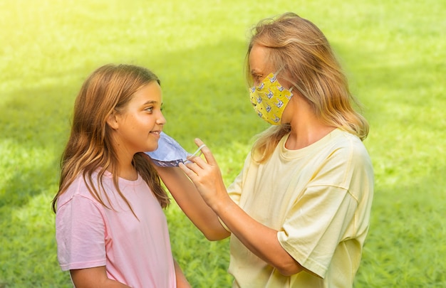 Familie mit Kindern in Gesichtsmaske im Park im Freien. Mutter und Kind tragen während des Ausbruchs von Coronavirus und Grippe eine Gesichtsmaske. Viren- und Krankheitsschutz