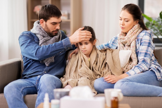 Foto familie mit kranker tochter mit fieber zu hause