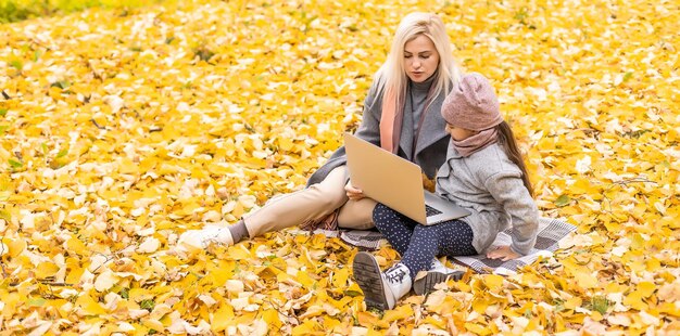 Familie mit Laptop an einem Herbsttag