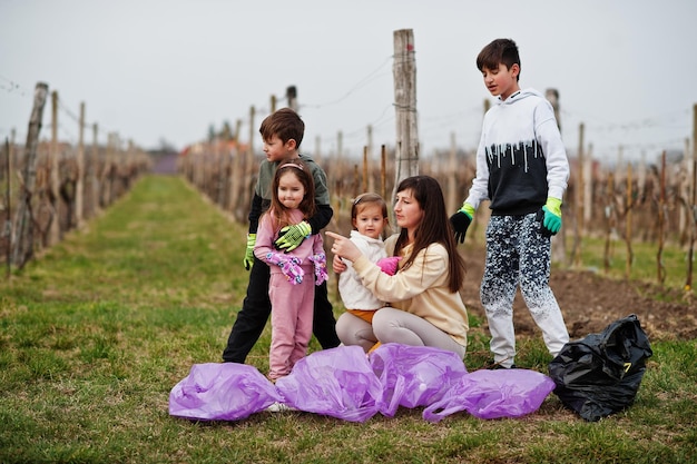 Familie mit Müllsack sammelt Müll beim Reinigen in den Weinbergen Umweltschutz und Ökologie-Recycling