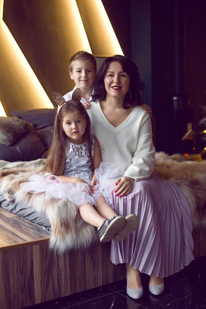 Familie Mutter Tochter Sohn sitzt zu Weihnachten im Bett