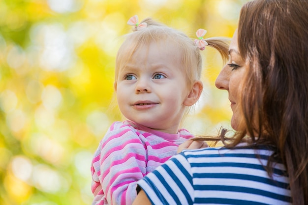 Familie Mutter und Tochter auf einem Spaziergang im Park im Herbst. In Mamas sicheren Händen