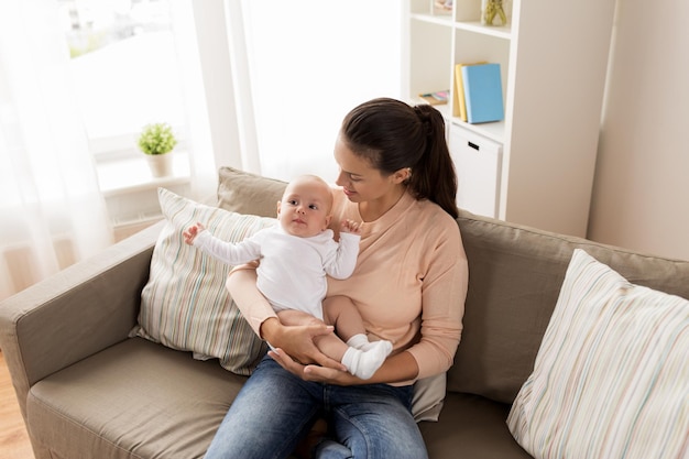 Familie, Mutterschaft und Menschen Konzept eine glückliche Mutter mit einem kleinen Jungen sitzt zu Hause auf dem Sofa