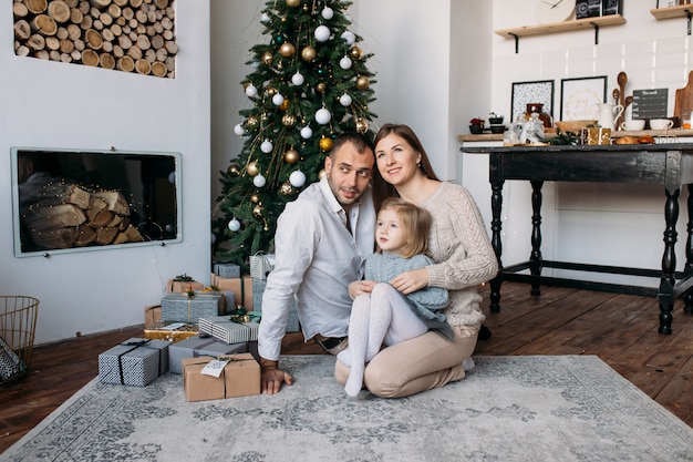 Familie nahe Weihnachtsbaum und Geschenken