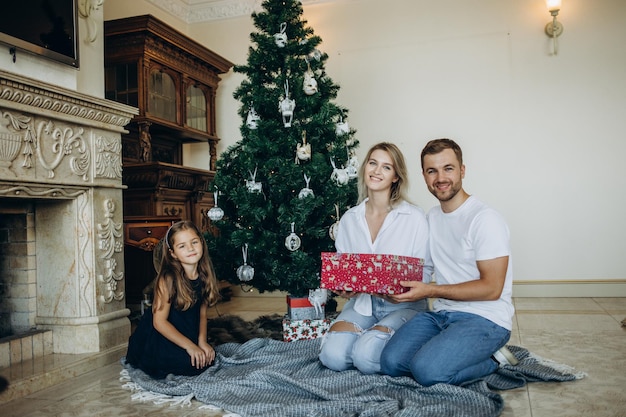 Familie öffnet Geschenke in der Nähe des Weihnachtsbaums