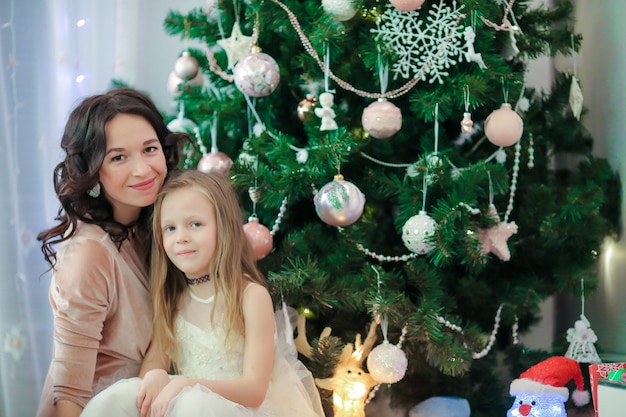 Familie og Mutter und kleine Tochter nahe dem Weihnachtsbaum auf Weihnachtsabend