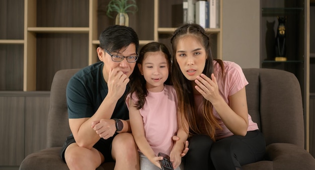 Familie schaut auf einer Couch fern