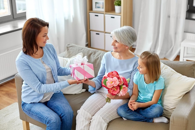 Familie schenkt Großmutter Geschenke und Blumen
