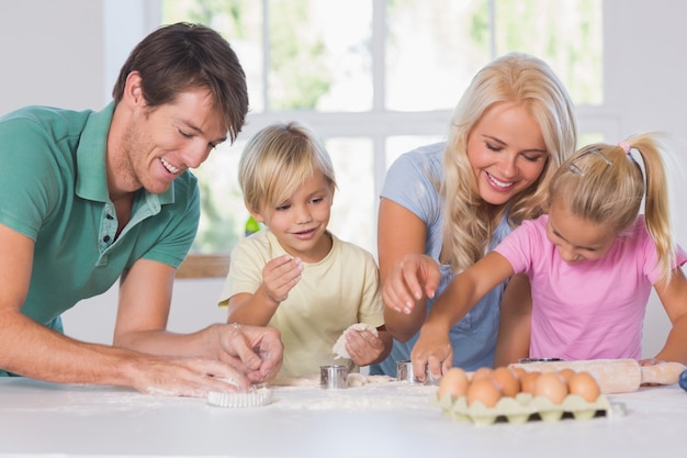 Familie schneidet den Teig