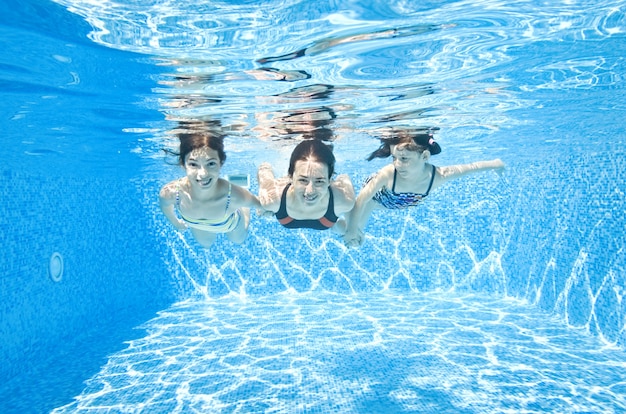 Familie schwimmt im Schwimmbad unter Wasser glückliche aktive Mutter und Kinder haben Spaß unter Wasser