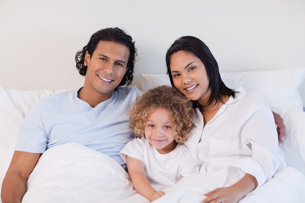 Familie sitzt auf dem Bett