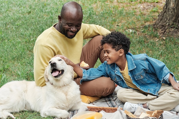 Familie sitzt mit Hund im Freien