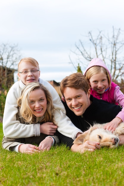 Foto familie sitzt zusammen auf einer wiese