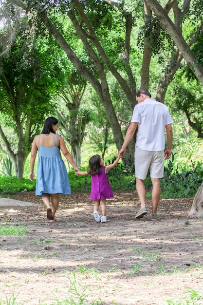 Familie spaziert an einem strahlenden Sommertag durch den Park