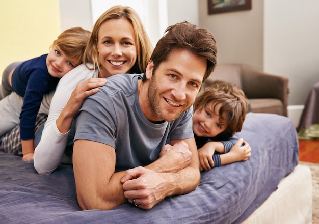 Familie steht an erster Stelle Porträt einer jungen Familie, die zu Hause verspielt ist