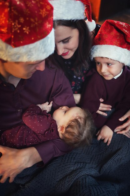 Foto familie trägt zu hause einen weihnachtsmannshut