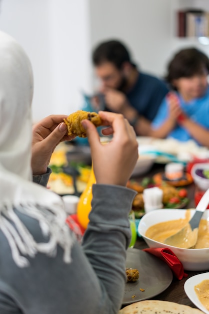 Familie und Freunde, die sich zusammen zu Hause für das Essen des Abendessens treffen