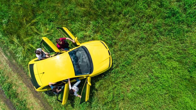 Familie und Freunde reisen mit dem Auto in den Urlaub, glückliche Eltern und Kinder auf Urlaubsreise aus der Luft