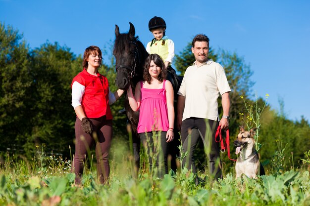 Familie und Kinder posieren mit Pferd