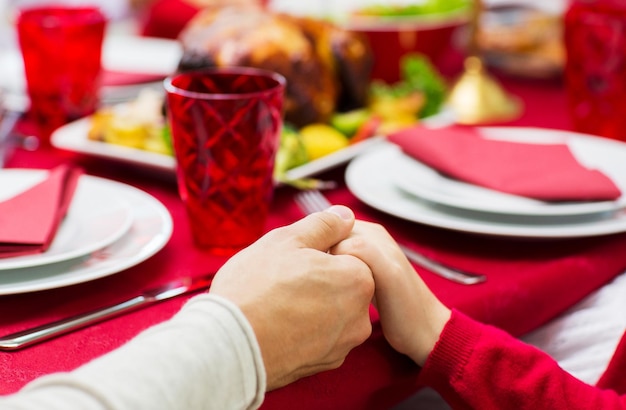 familie, urlaub, tradition, generation und personenkonzept - nahaufnahme der familie, die weihnachtsessen hat und zu hause hände hält