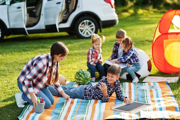 Familie verbringt Zeit zusammen Mutter mit vier Kindern im Freien in Picknickdecke und Kinderzelt