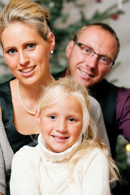 Familie vor Weihnachtsbaum